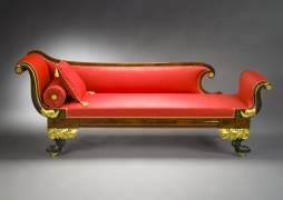 Récamier in the Neo-Classical Taste, about 1820. Attributed to Duncan Phyfe, New York. Mahogany, partially gilded and painted verde antique, with die-stamped gilt-brass mounts, ­bolster buttons, and castors, and die-stamped brass inlaid with ebony. 32 in. high, 82 3/4 in. long, 24 1/2 in. deep