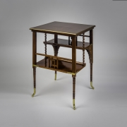 "Tiered Table in the Aesthetic Taste," about 1880. A. & H. Lejambre (active 1865–1907), Philadelphia. Mahogany, with inlays of brass, copper, and pewter, and brass moldings, straps and sabots, 27 in. high, 20 in. wide, 20 in. deep,