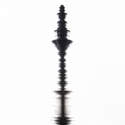 a sculpture by Elizabeth Turk of black aluminum discs stacked and arranged to simultaneously resemble a Modernist abstraction and a sound wave