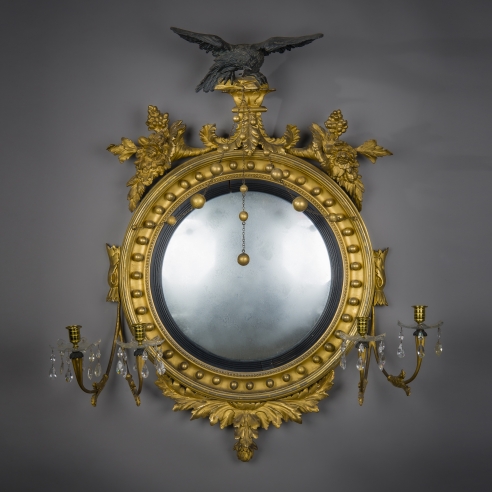 Neo-Classical Convex Girandole Mirror with Candle Arms, about 1810. American, probably Salem, Massachusetts. Eastern White Pine, gessoed and gilded, and partially ebonized, with convex mirror plate, glass drip pans, blown and cut, glass prisms, gilt-brass candle cups and bobeches, and brass chain 43 in. high, 38 in. wide, 10 5/8 in. deep.